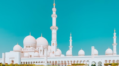 white and blue mosque under blue sky during daytime