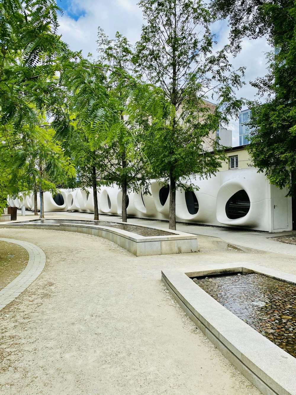 green trees near white concrete building during daytime