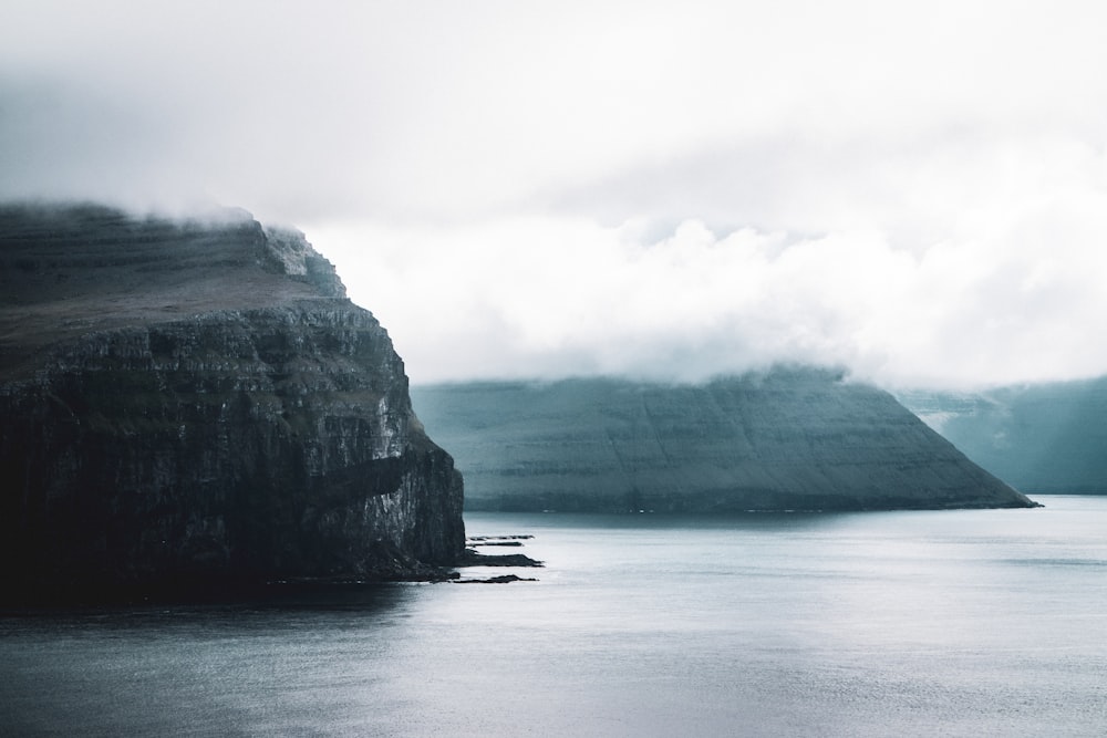 body of water near mountain during daytime