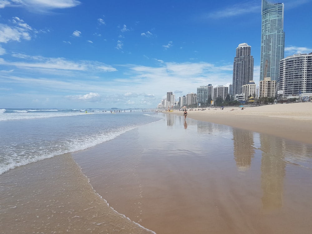 city skyline across the sea under blue and white cloudy sky during daytime