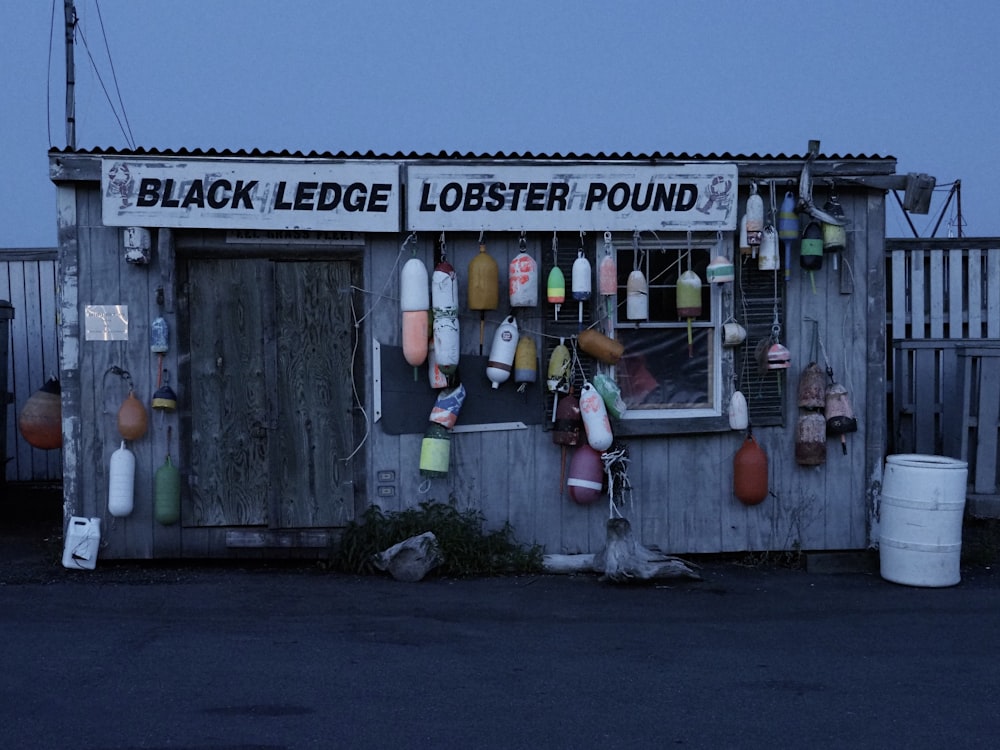 a shack with a lot of buoys hanging from it's side