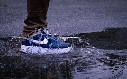 person in blue and white nike sneakers standing on water