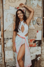 femme en robe à rayures blanches et roses debout près d'un mur onlyfans