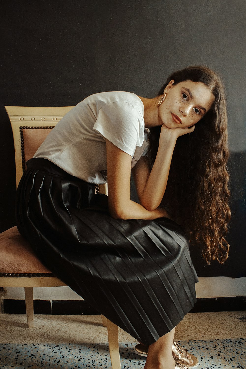 woman in white shirt and black skirt sitting on brown sofa