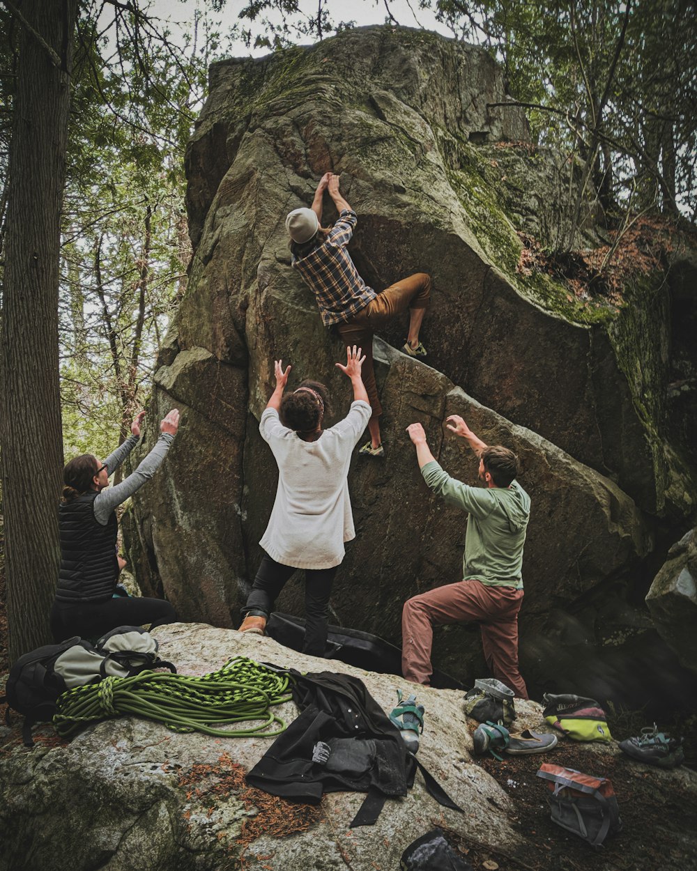 groupe de personnes en chemise blanche à manches longues et pantalon vert debout sur un sol rocheux