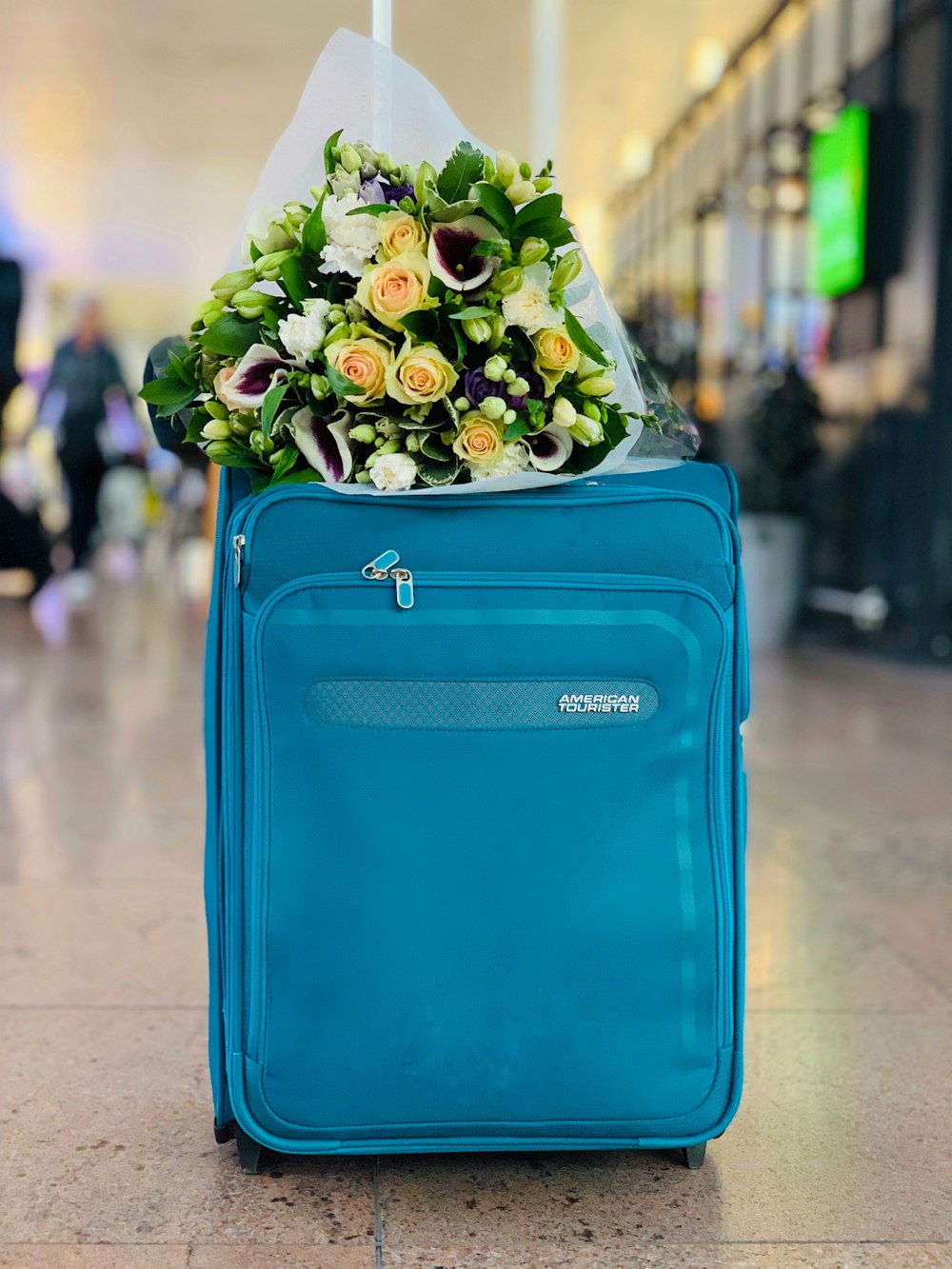 bouquet of flowers on blue luggage
