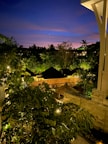 Evening shot of villa lit softly against the dark jungle backdrop.
