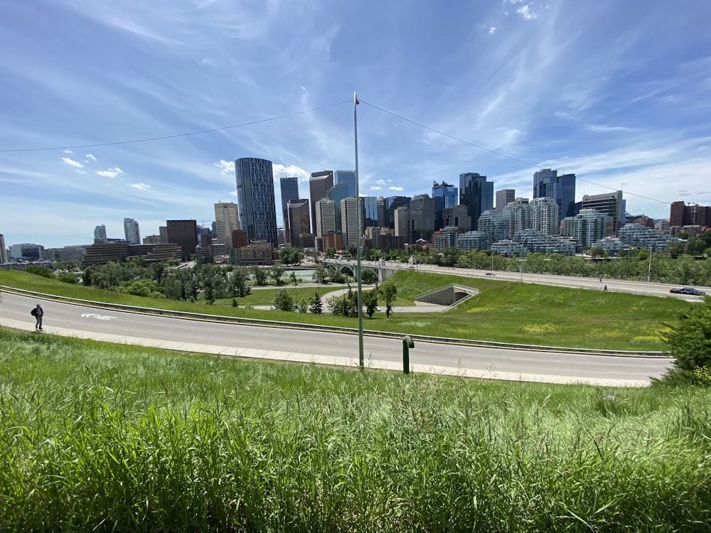 green grass field near city buildings during daytime