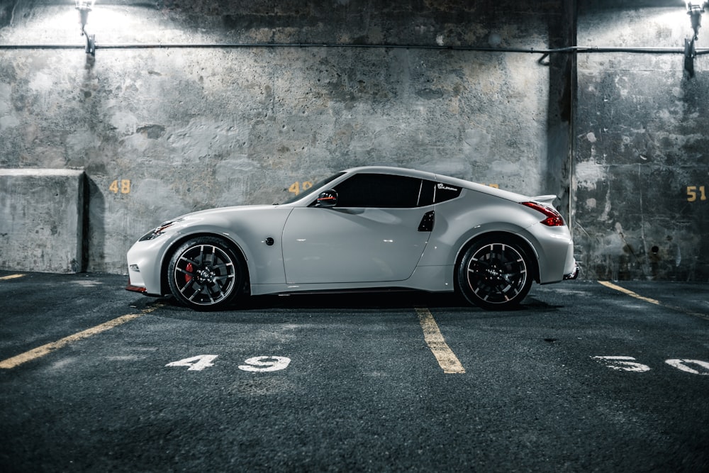 white porsche 911 parked on grey concrete pavement