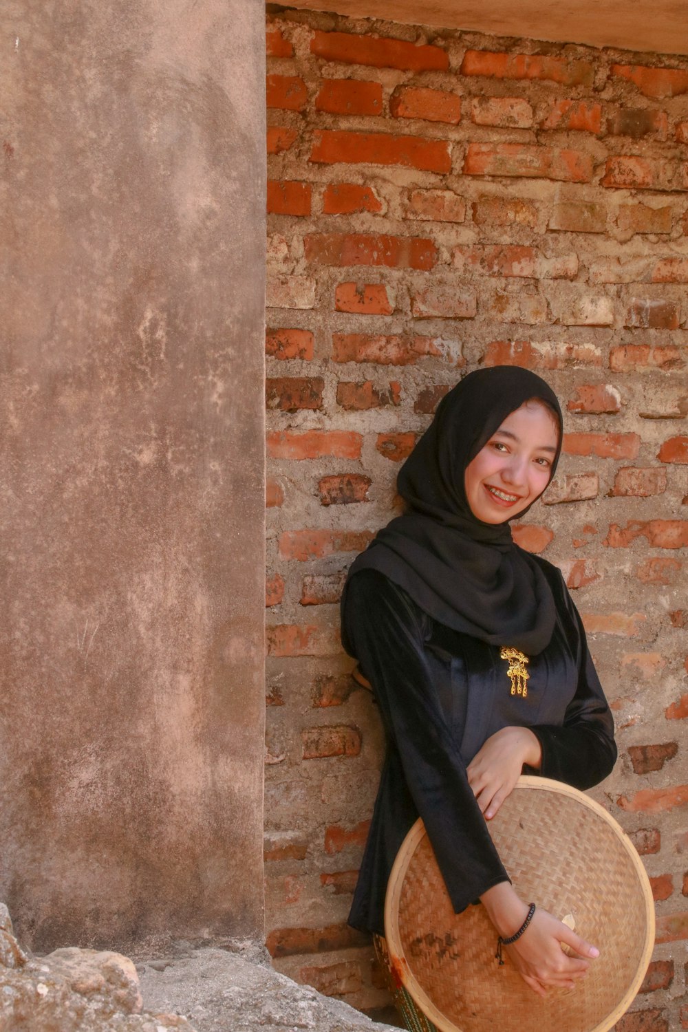 donna in hijab nero e camicia nera a maniche lunghe seduta sulla sedia marrone