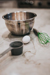 A set of colorful mixing bowls stacked neatly on a marble countertop.