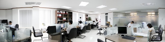 A friendly team of cleaners in uniform working together in a bright, tidy office space.