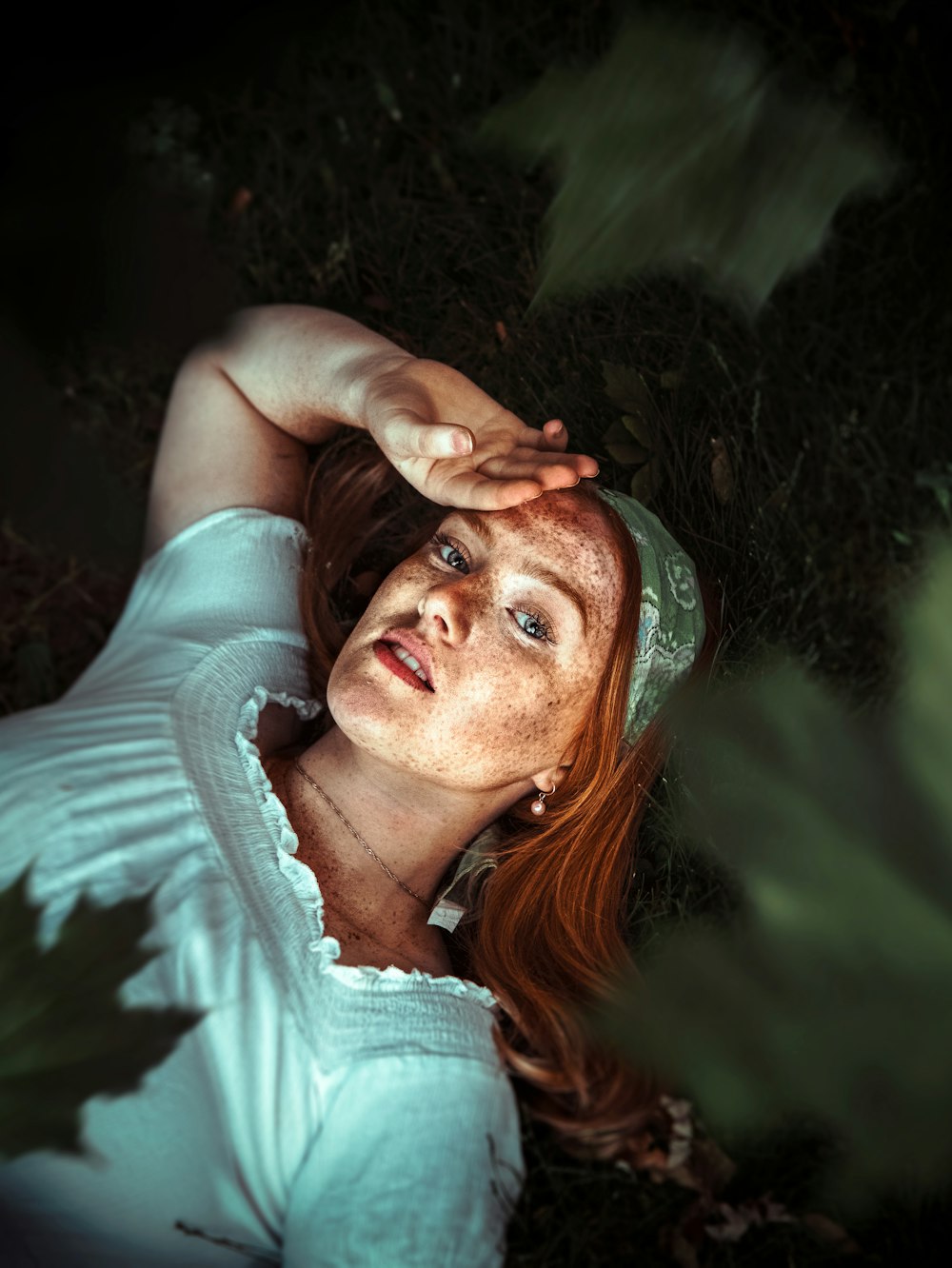 woman in white shirt lying on green grass