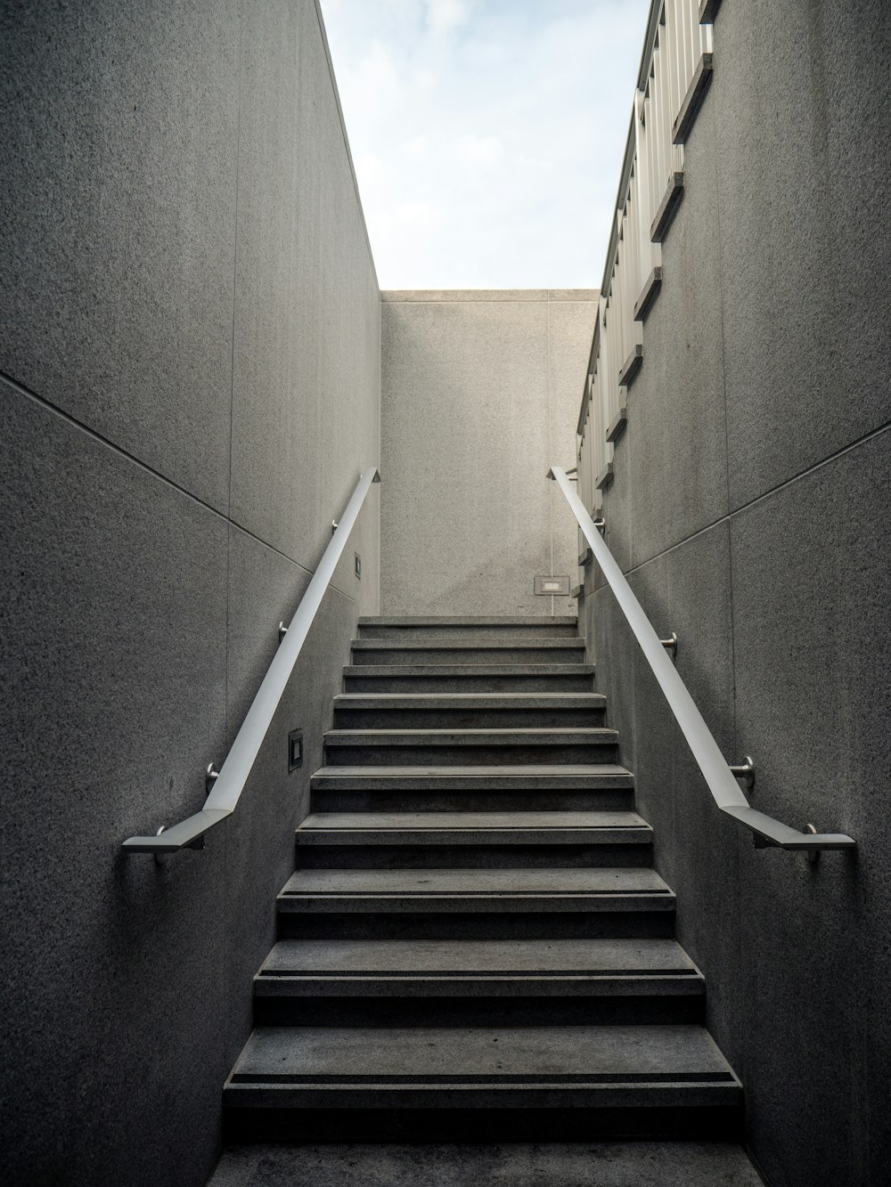 ステンレス鋼の手すりが付いている灰色の具体的な階段