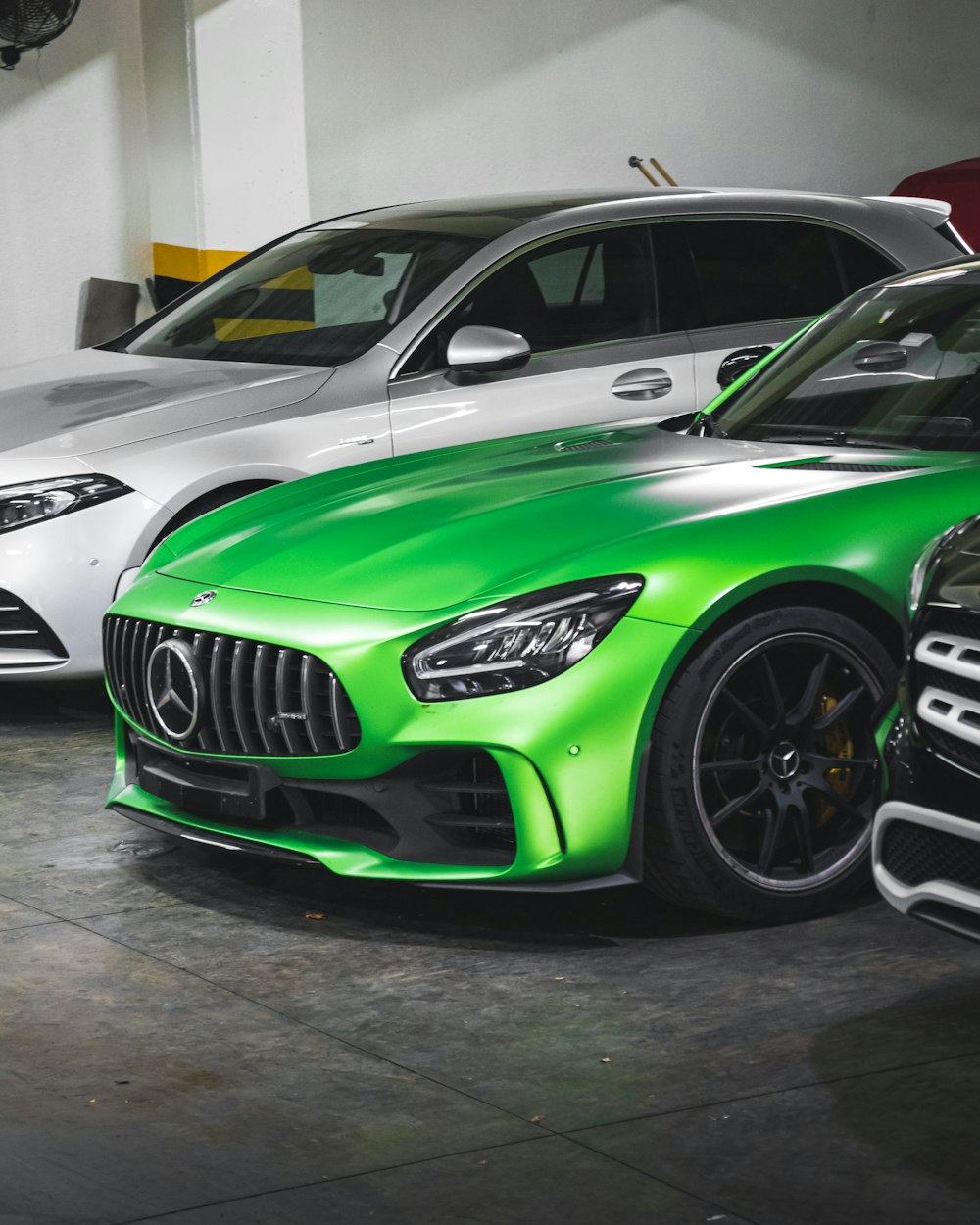 green bmw m 3 coupe parked on gray concrete floor