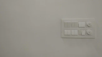 A sleek modern electrical meter and switches displayed on a clean white background.