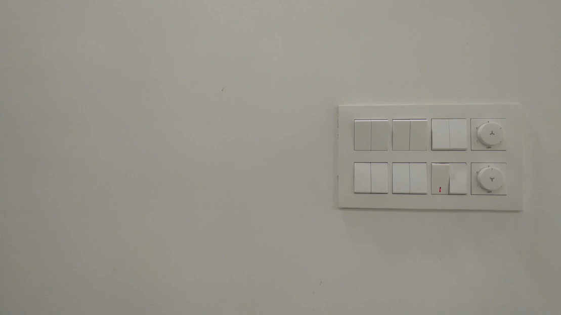 A sleek modern electrical meter and switches displayed on a clean white background.