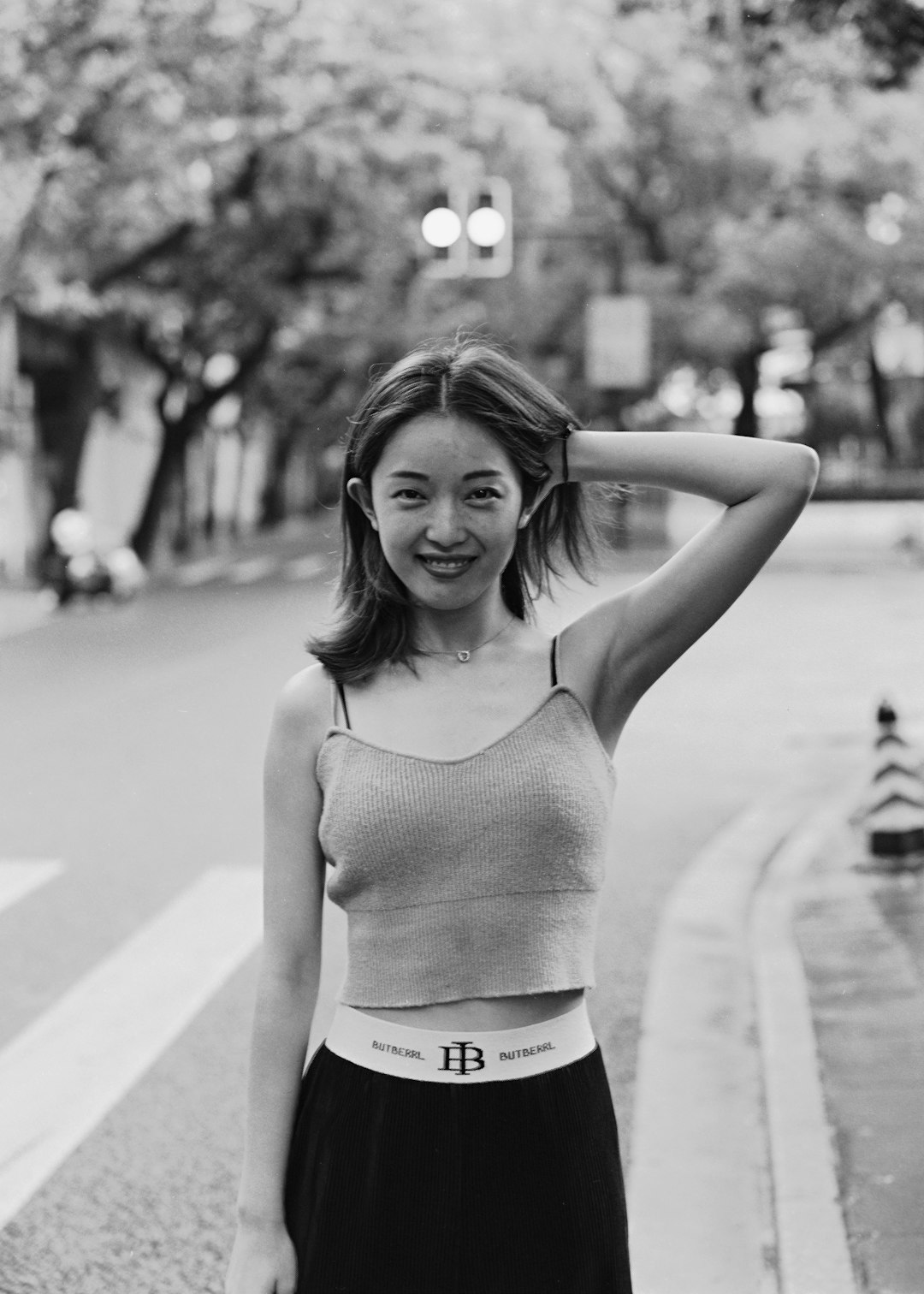 woman in tank top and white shorts standing on road