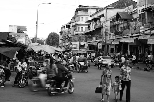 grayscale photo of people riding motorcycle on road in Phnom Penh Cambodia