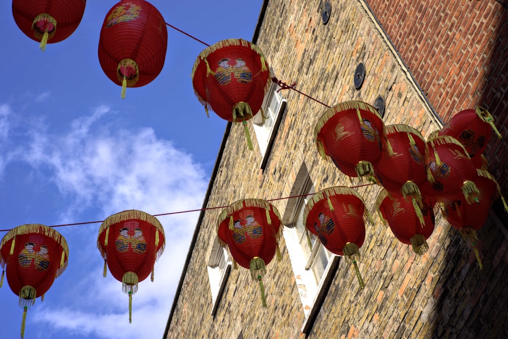 red paper lanterns hanging on brown wooden building during daytime