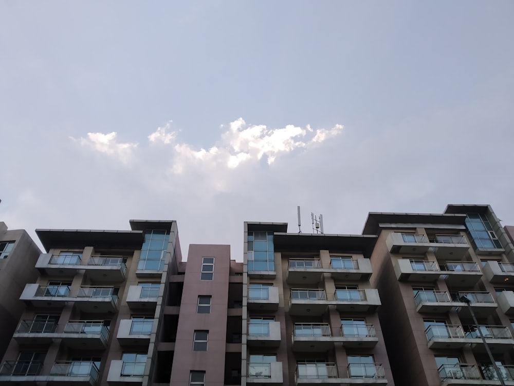 Edificio de hormigón marrón y blanco bajo el cielo azul durante el día