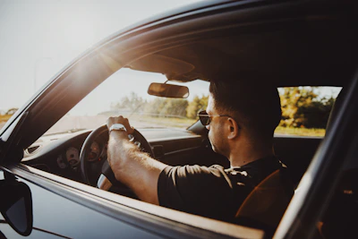 man in black jacket driving car during daytime