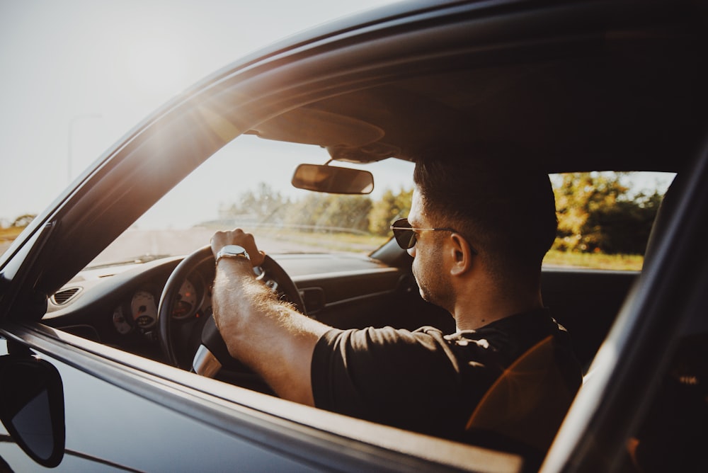 man in black jacket driving car during daytime