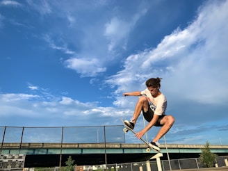 Close-up of a skateboarder mid-air performing a trick against a clear blue sky