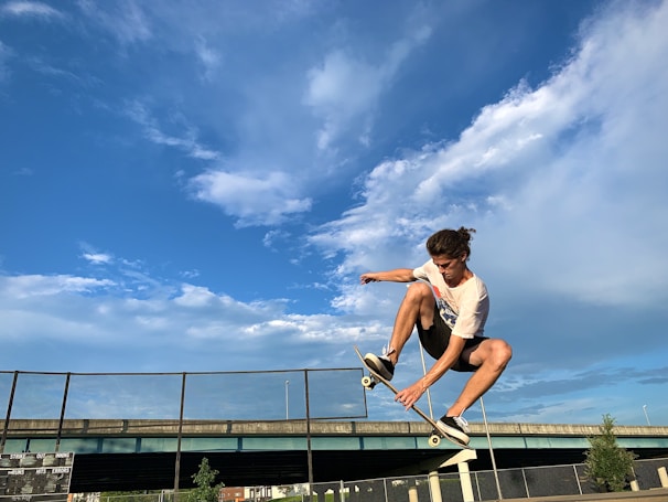 A creative shot of a skateboard mid-air against a clear blue sky.