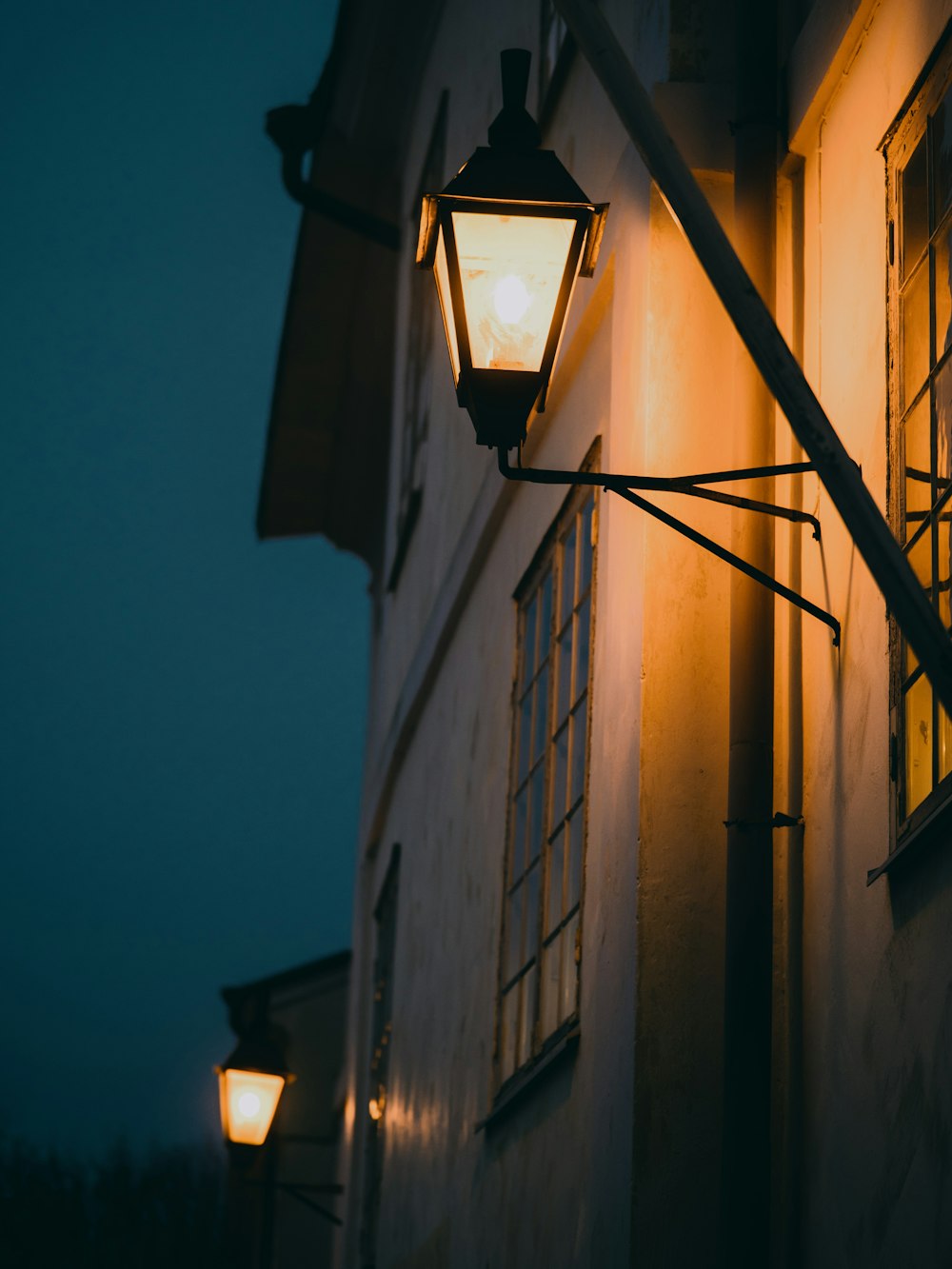 black outdoor sconce turned on during night time