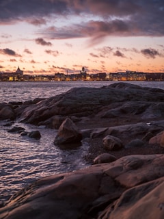 gray rocks on sea shore during sunset