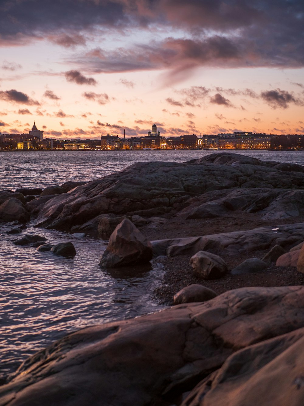 gray rocks on sea shore during sunset