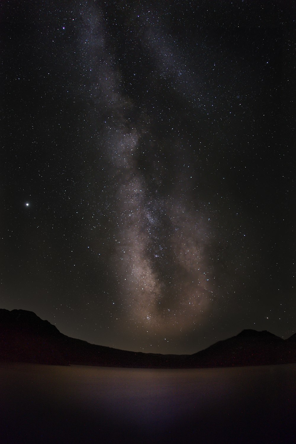 silhouette of mountain under starry night