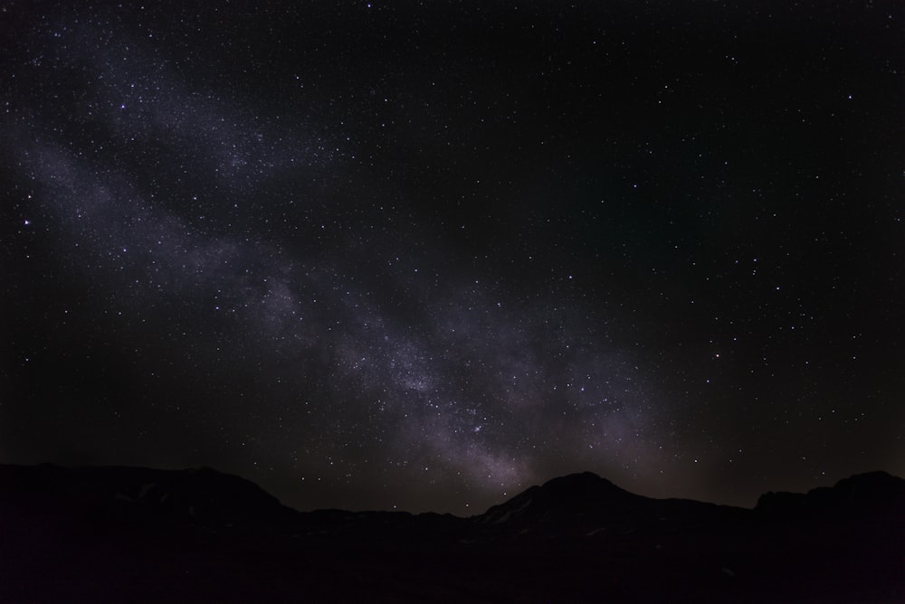 silhouette of mountain under starry night