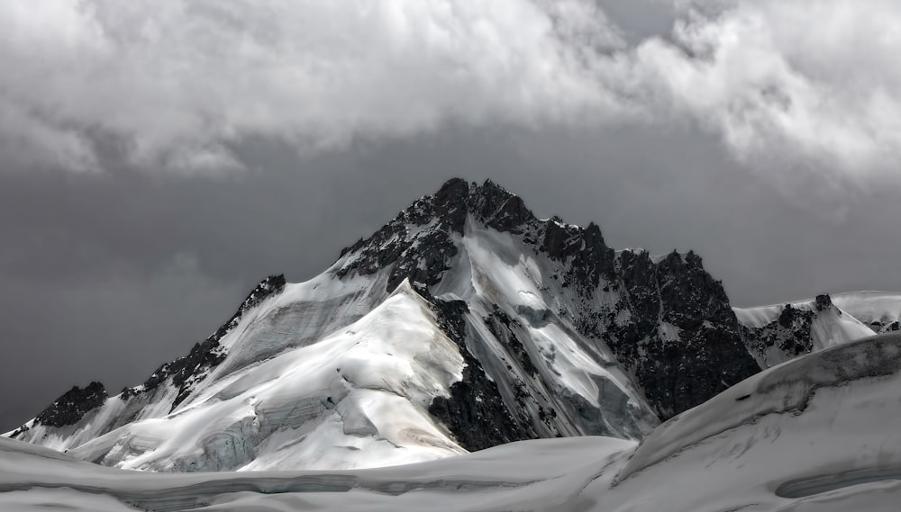 snow covered mountain under cloudy sky during daytime