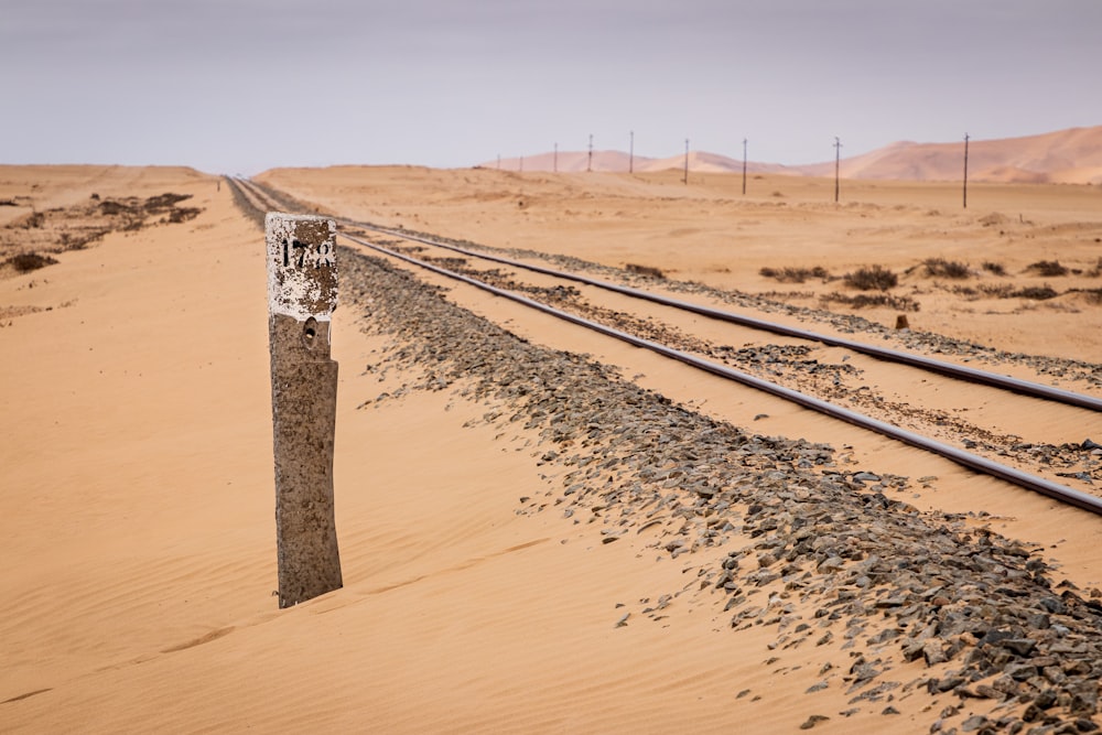 brown wooden post on brown sand during daytime