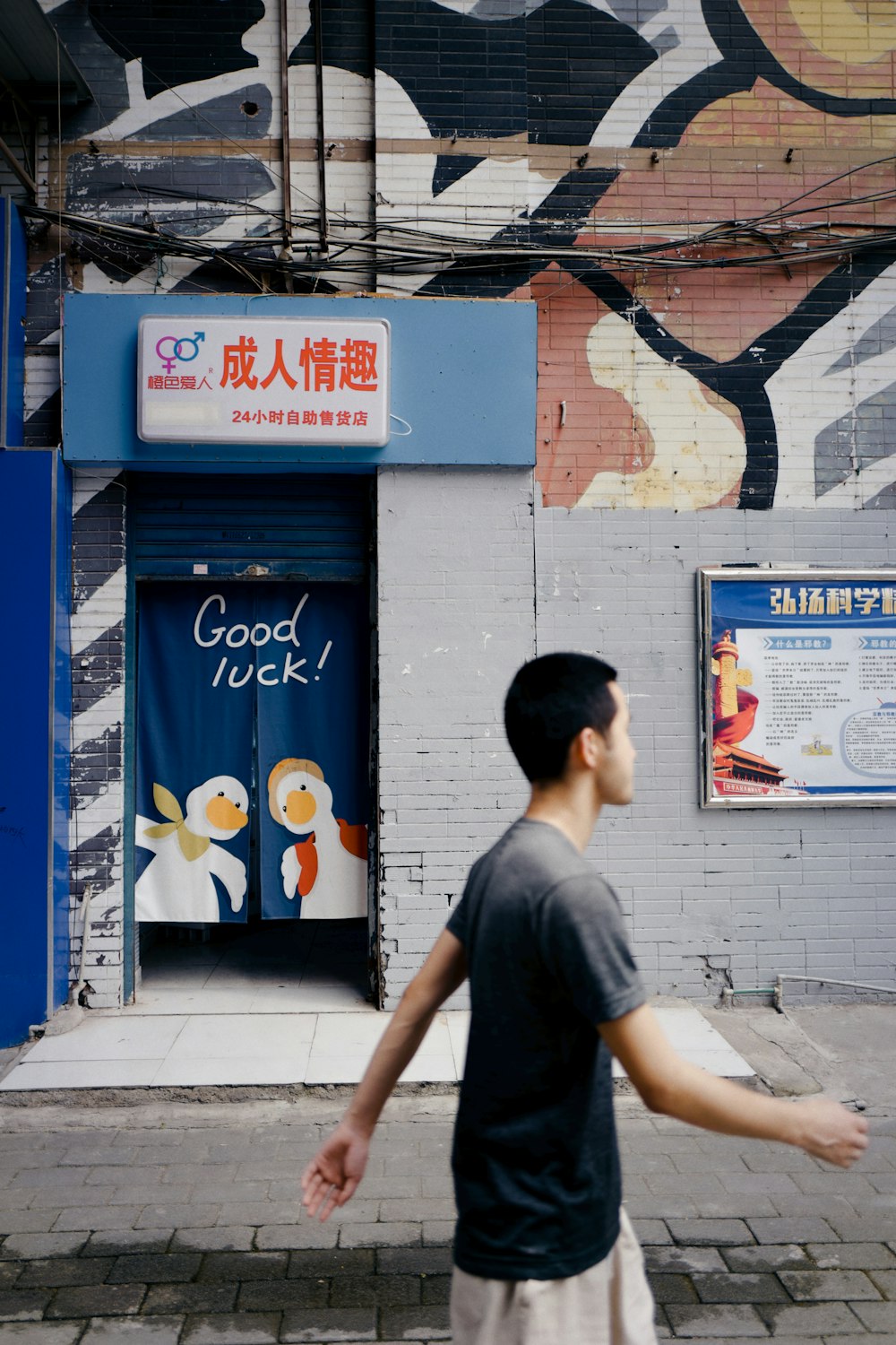 man in gray crew neck t-shirt standing near blue and white concrete building during daytime