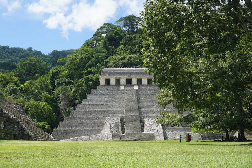 昼間の緑の木々の近くの灰色のコンクリートの建物