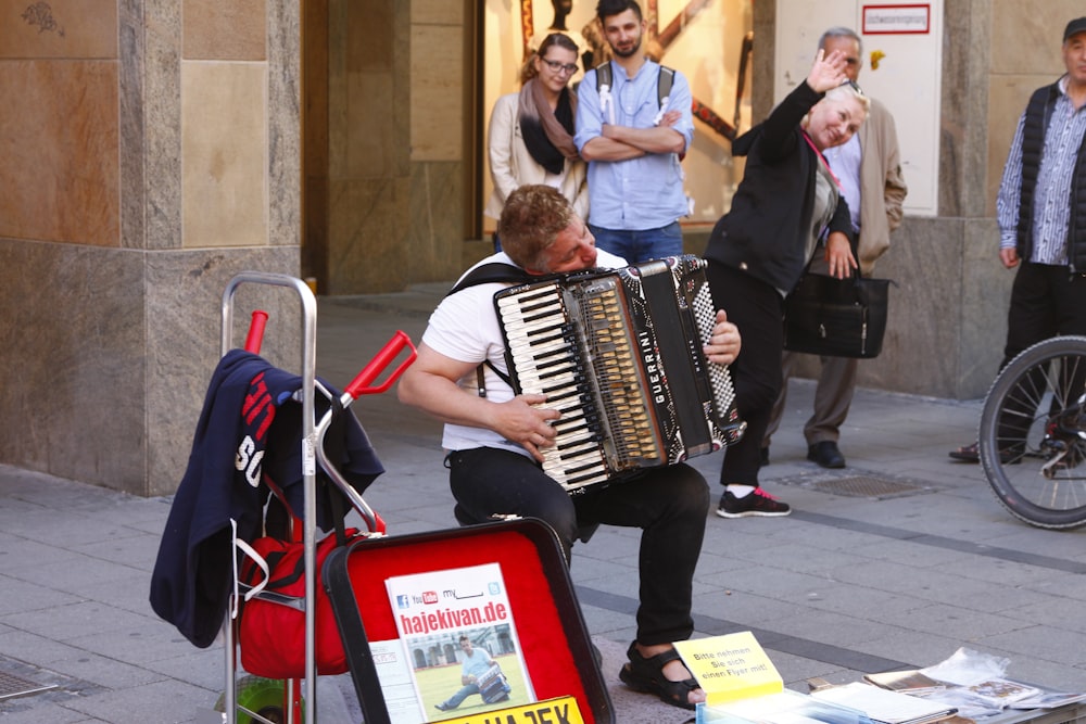 man in black suit playing black and white piano