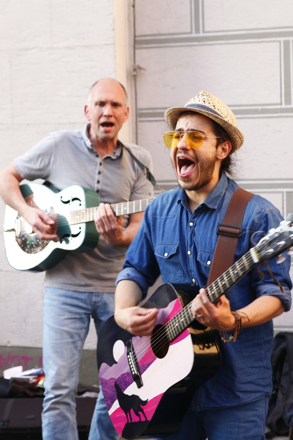 man in blue button up shirt holding white electric guitar