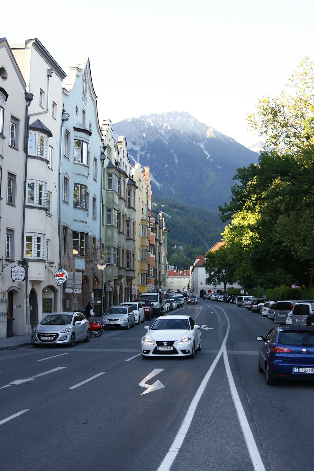 cars parked beside white concrete building during daytime