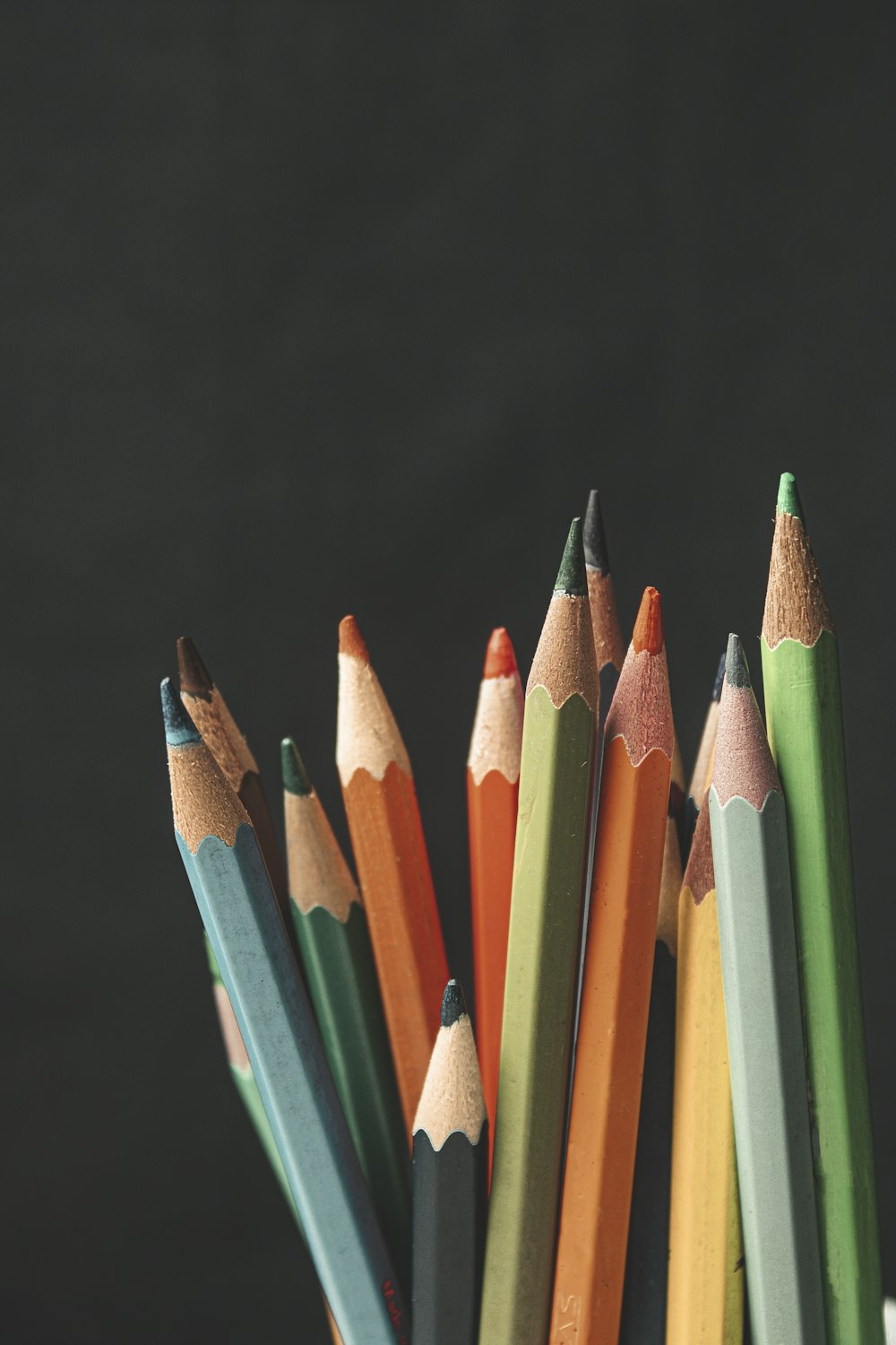 a group of colored pencils sitting in a cup