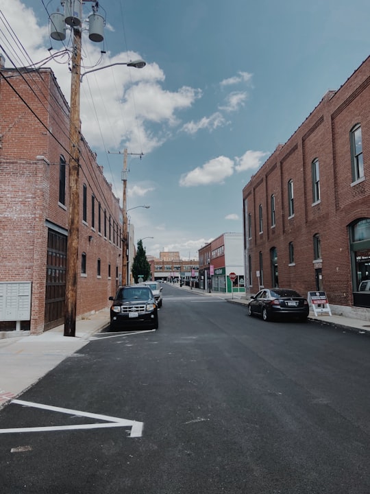 black car parked beside brown concrete building during daytime in Downtown United States