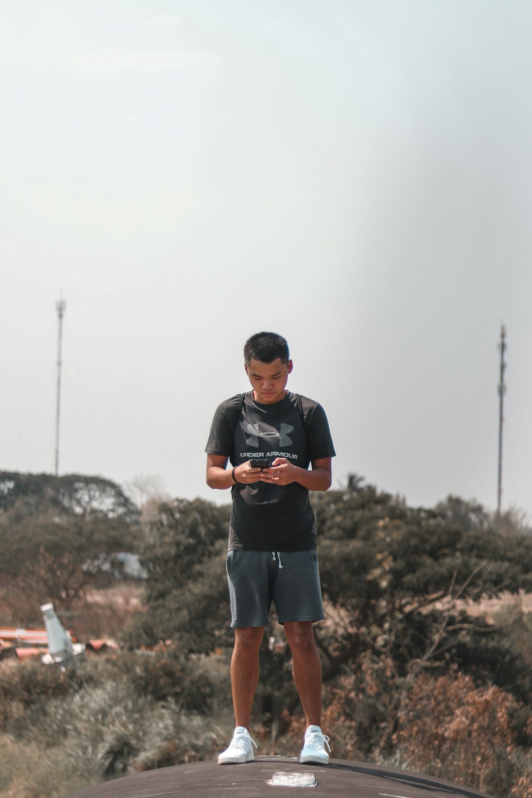 man in black crew neck t-shirt and blue denim shorts holding black dslr camera