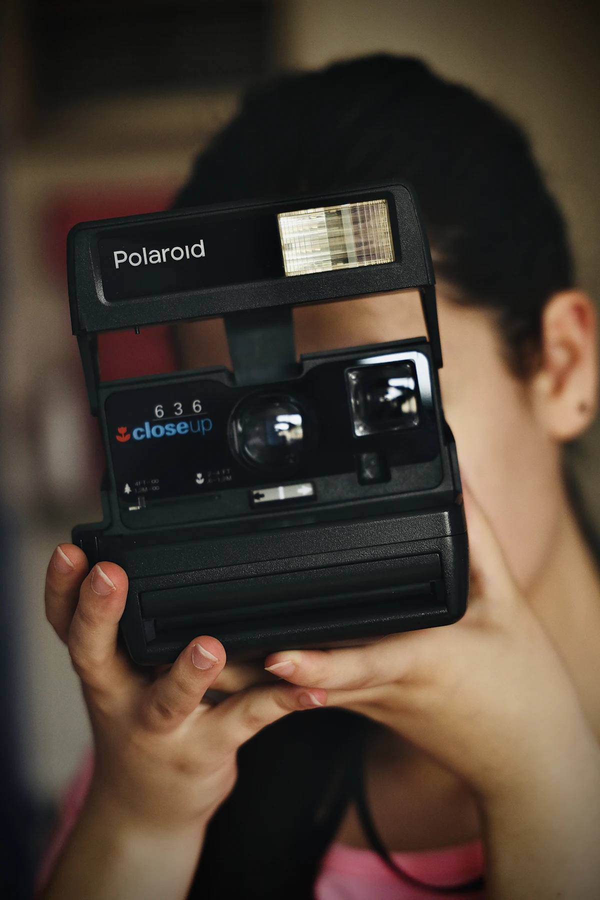 Kamera polaroid hitam di atas meja kayu sebagai inspirasi throwback estetik era 2016 untuk konten TikTok nostalgia