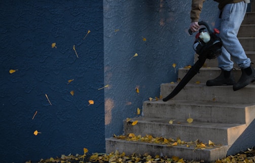 man in black jacket and pants standing on stairs