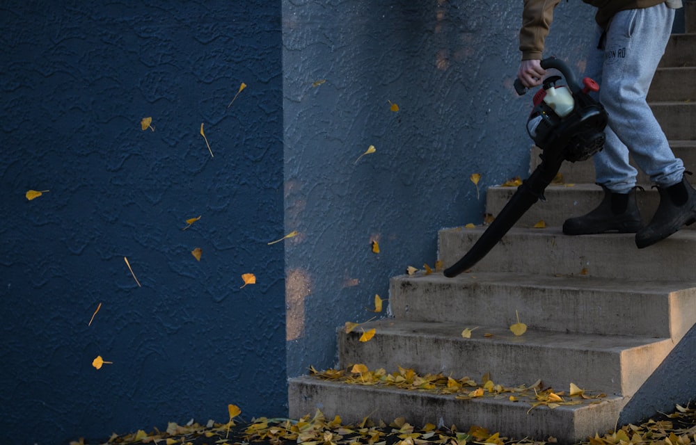 Mann in schwarzer Jacke und Hose steht auf der Treppe