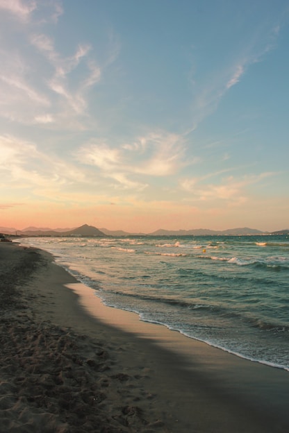 sea waves crashing on shore during sunset