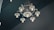 A chandelier composed of metal gears and bicycle parts with exposed light bulbs hanging from a ceiling. The design integrates industrial elements, featuring sprockets and a wheel in a creative arrangement.