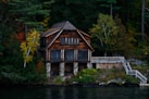 brown wooden house near body of water during daytime